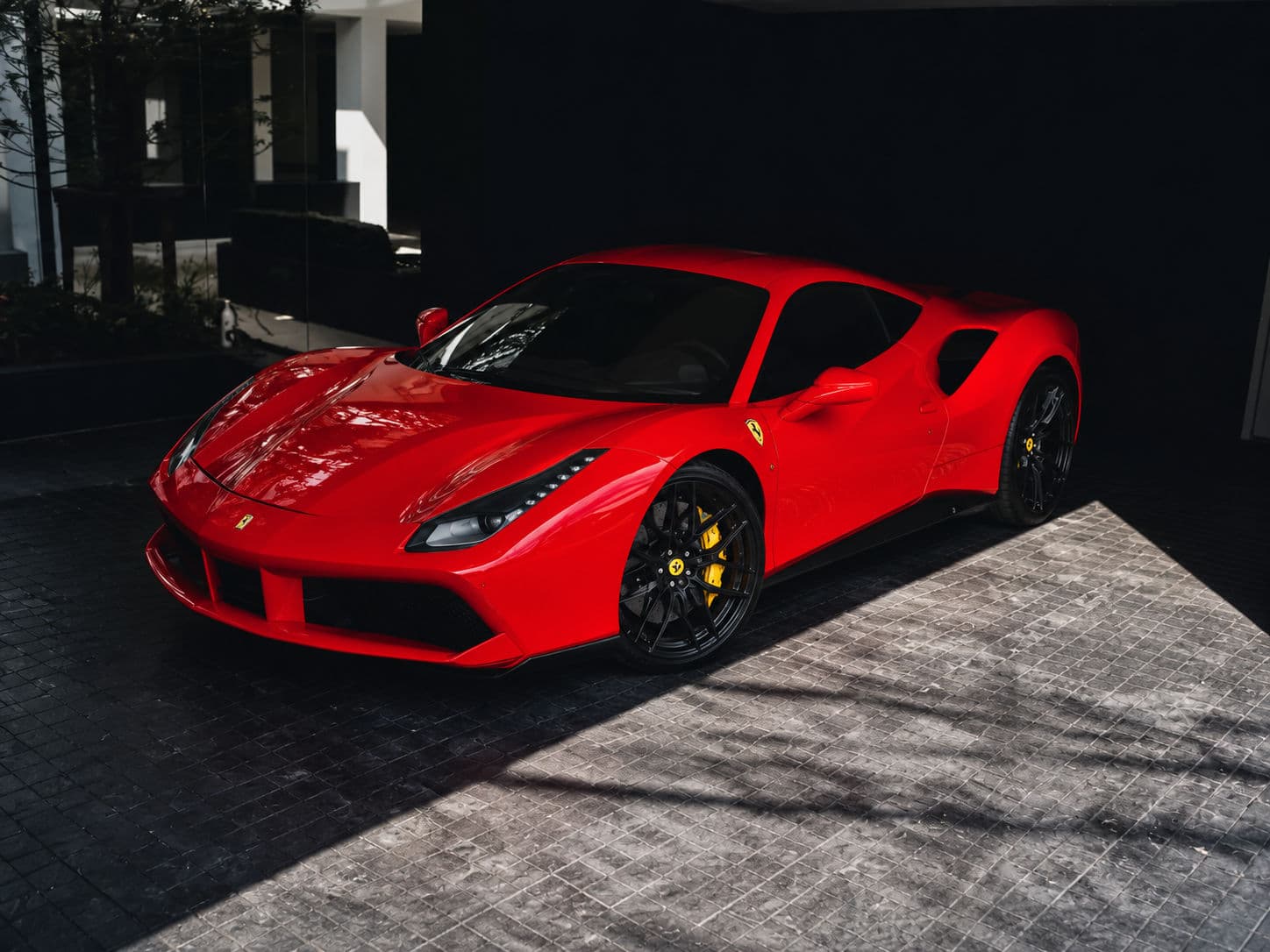 488 GTB: Red Ferrari 488 GTB parked by a modern building, front three-quarter view — RC24.