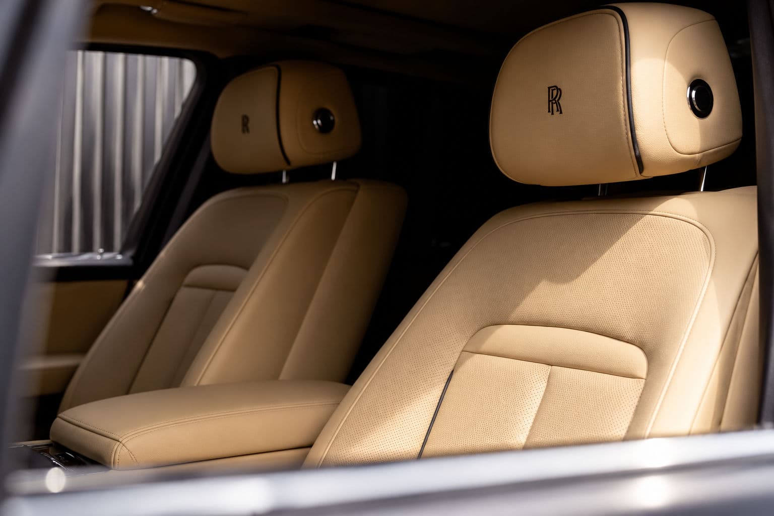 Cullinan: Rolls-Royce Cullinan 2024 front seats in beige leather with embroidered RR monograms on the headrests — RC24