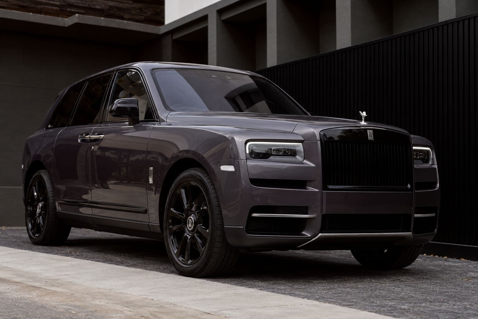 Cullinan: Rolls-Royce Cullinan 2024 in grey, low-angle front three-quarter view with black grille and alloy wheels — RC24