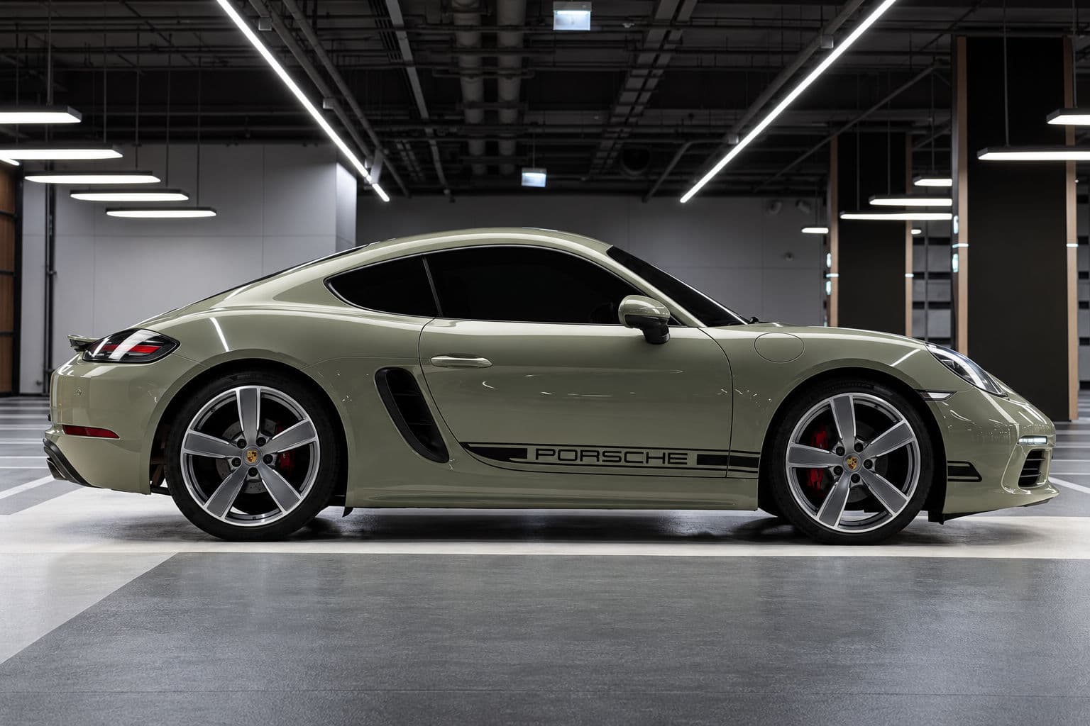718 Cayman: Porsche 718 Cayman 2024 in Imperial Khaki, side profile indoors