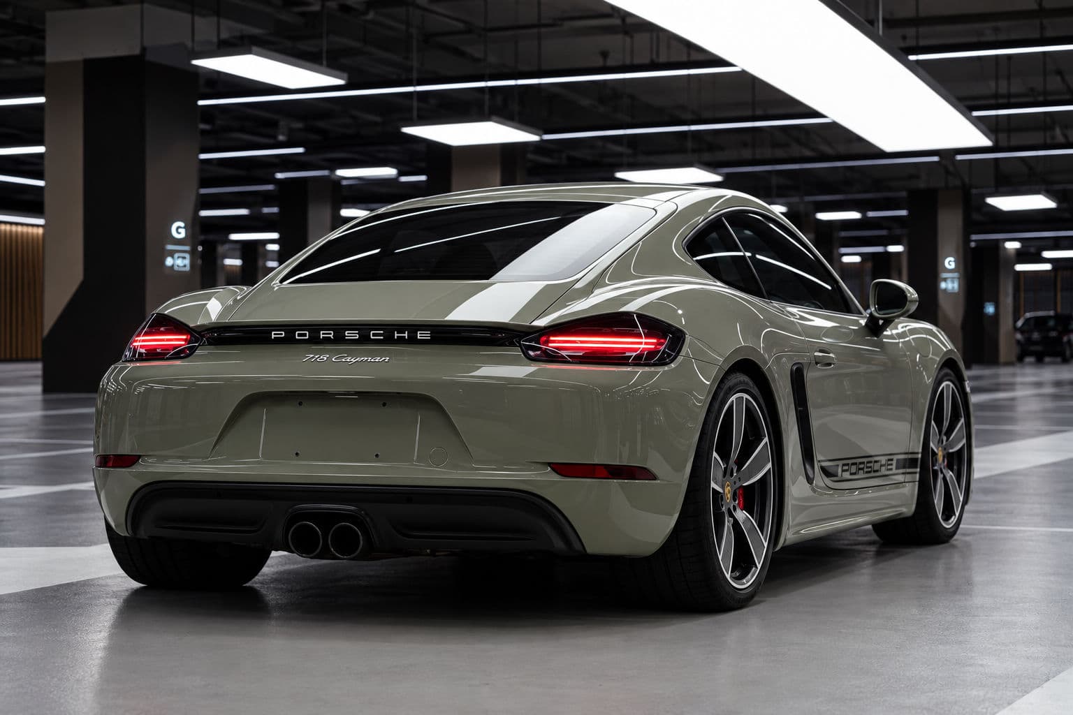 718 Cayman: Porsche 718 Cayman 2024 in Imperial Khaki, rear three-quarter view indoors