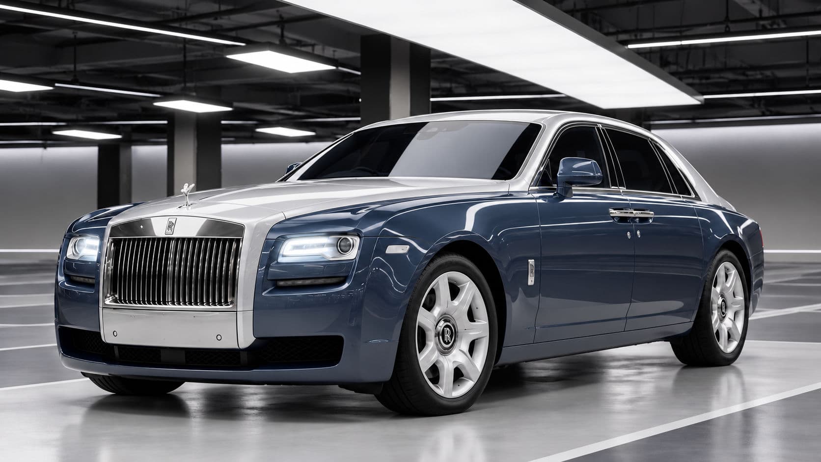 Ghost: Rolls-Royce Ghost 2019, front three-quarter view in a lit indoor garage, slate blue body with silver bonnet and roof, pantheon grille and Spirit of Ecstasy