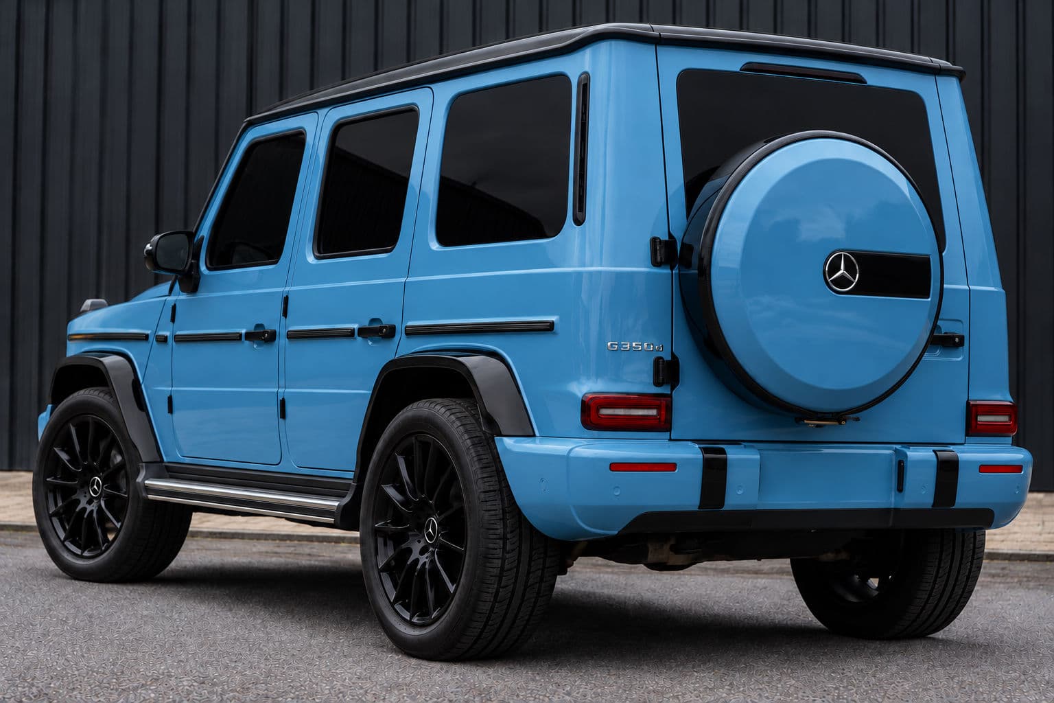 G350: Mercedes-Benz G350 2022 in Vintage Blue, rear three-quarter view with spare wheel cover and black alloy wheels